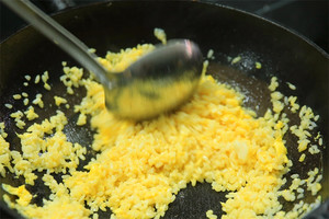 大火加熱炒鍋，再入油，燒到四至五成熱時倒入雞蛋液，在未凝結之前，加米飯煸炒，不停翻炒并用鍋鏟將成塊的米飯碾開、撥散。