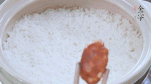 煮開后轉(zhuǎn)小火，當(dāng)米飯出現(xiàn)小孔時，鋪上金字麻辣香腸。