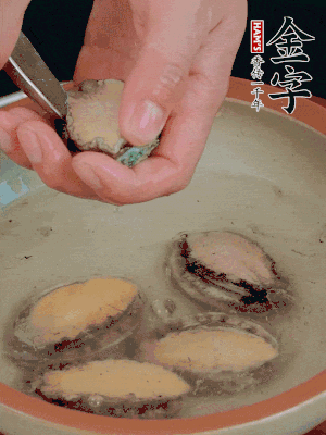 鮑魚加鹽、清水浸泡，用勺子挖出鮑魚肉。