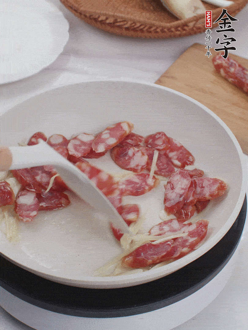 油溫3成熱時，下姜絲、蒜片、香腸炒出油脂。