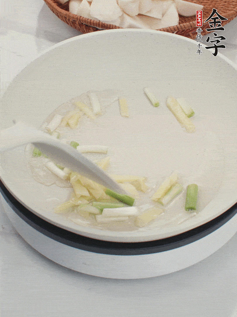 鍋中油五成熱，下蔥白、姜片爆香。