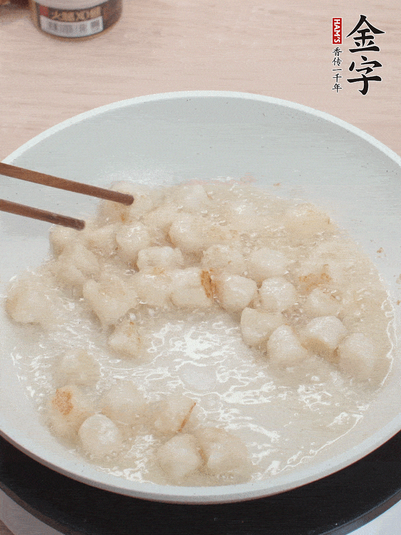 油溫4成熱，鮮貝蘸干淀粉下鍋煎，一面微黃后翻面。