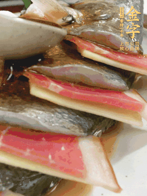 魚肚中塞蔥結(jié)、火腿片，魚身上碼放姜片、火腿片，倒入混合的料汁。