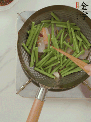 下掰好的缸豆段翻炒，略燜煮。