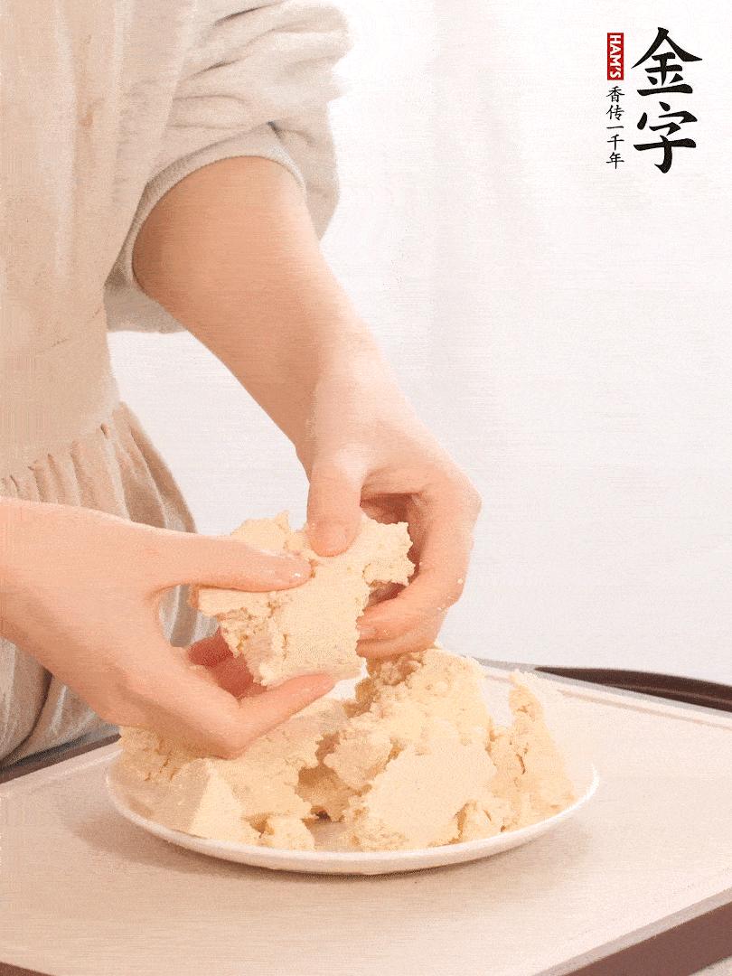 老豆腐用手掰成塊。