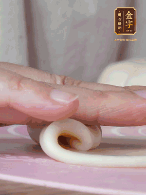 做面劑 油皮按扁，中間包入一個(gè)油酥，邊緣收緊捏死。包好的面劑按扁，用搟面杖搟壓成橢圓形。從底部向上卷成筒狀，用保鮮膜蓋好松弛15分鐘，再把筒狀縱向搟壓成長條狀。再卷一次，松弛20分鐘