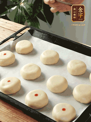 收口向下放在案板上，輕輕將月餅坯按扁，用筷子點(diǎn)紅點(diǎn)做裝飾