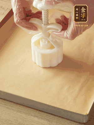 取一個(gè)面團(tuán)，捏扁，中間厚，四周薄?；⒖谕贤?，直到收口，把餅胚放入模具里，壓2-3下