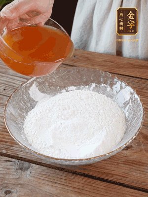 轉(zhuǎn)化糖漿、枧水、花生油攪拌均勻，加入面粉混合，醒發(fā)2小時。捏成23g一個的小球