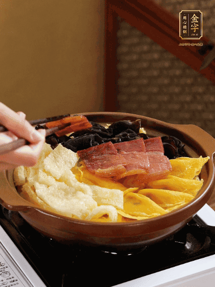 砂鍋底部鋪上娃娃菜，依次擺上肉皮、蛋餃、黑木耳、火腿